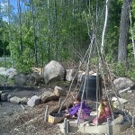 Sylvana and Stephanie plant peas inside their Pea Teepee. Vines will grow up and over the poles and eventually cover the whole teepee.
