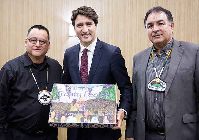 Anishinabek Nation Grand Council Chief Patrick Madahbee and Fort William First Nation Chief Peter Collins present Prime Minister Trudeau with both French and English versions of the 'We are all Treaty People' teachers treaty relationship resource on April 8 in Thunder Bay.