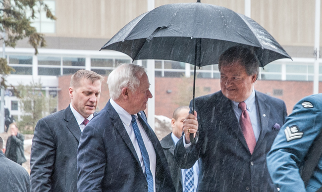 President Mike Degagné holds an umbrella over Governor General David Johnston walking into Nipissing University. 