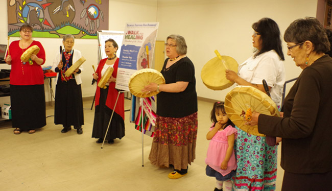 Fort William hand drummer Rita Fenton, left of Walk for Healing sign, participates in the April 22 Heartbeat of the Drum – A Walk for Healing announcement at the Thunder Bay Indian Friendship Centre. The walk is scheduled for 12:30 on May 8.