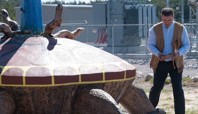 Dokis First Nation Deputy Chief Gerry Duquette Jr. blesses Okikendawt Power's new turtle sculpture by former Chief Martin Restoule. 