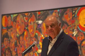 Chippewas of Rama First Nation's William Kingfisher, curator, discussed work of Arthur Shilling in front of 30-foot mural, The Beauty of My People, by Arthur Shilling, at the June 10 opening of the Arthur Shilling: The Final Works exhibition at the Thunder Bay Art Gallery. 