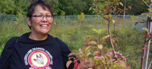 Biinjitiwaabik Zaaging Anishinaabek Councillor Lorraine Cook checks out one of the 16 fruit trees that the community planted two years ago near the Lake Nipigon shoreline.